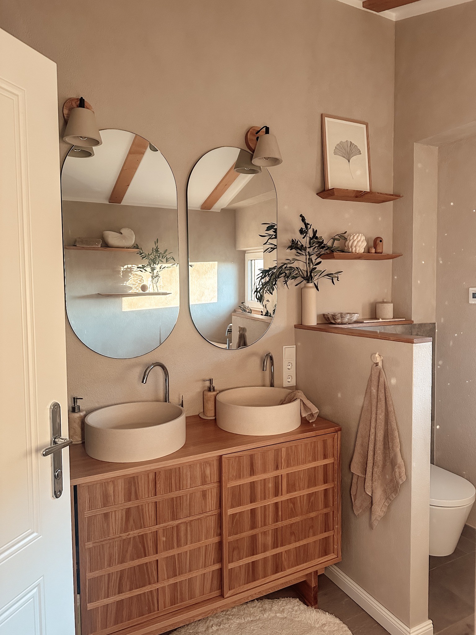 Badezimmer mit Holzwaschtisch und natürlichen Oberflächen